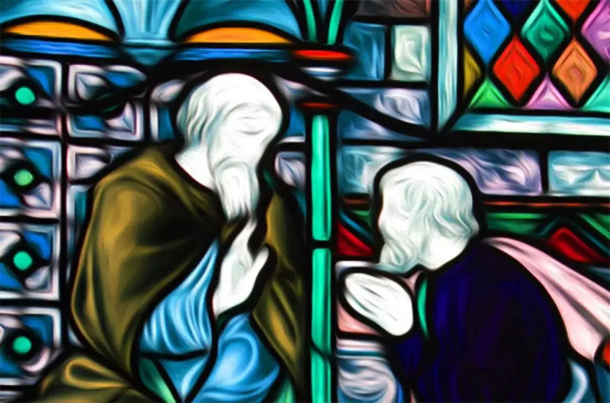 A stained glass window in rich colored glass showing a penitent man kneeling in confession before a robed elder whose hand is raised.
